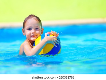 cute kid playing water sport games in pool