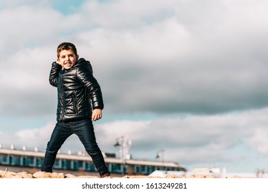 Cute Kid Throwing Rocks With Cloudy Sky Background