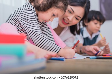 Cute kids and Asian teacher drawing in artist class. Back to school and education concept. Nursery and Preschool theme. Student and Baby sister theme.