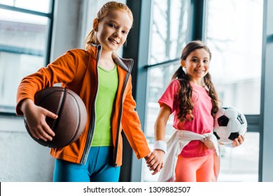 Cute Kids With Balls Holding Hands In Gym