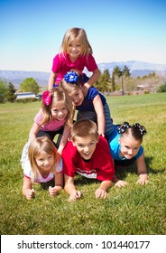 Cute Kids Building A Human Pyramid Outdoors