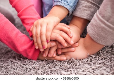 cute kids hands together on gray wool carpet, cheering pose - Powered by Shutterstock