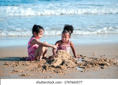 Cute Kids Having Fun On Sandy Summer Beach With Blue Sea, Happy Childhood Friend Making Sand Castle, Playing With Sandat On Tropical Beach