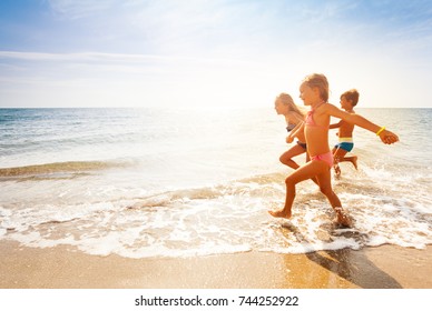 Cute Kids Having Fun On Sandy Beach In Summer