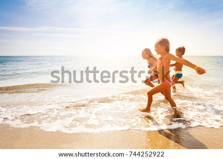 Cute kids having fun on sandy beach in summer