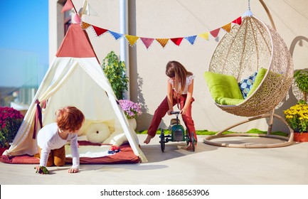 Cute Kids Having Fun, Playing With Toys On Summer Patio