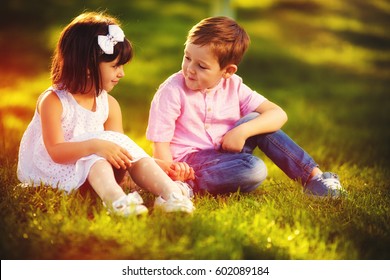 cute kids in love, sitting together in spring garden