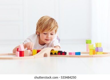 cute kids playing with toy railway road at home