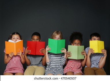 Cute kids reading books on grey background