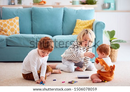 cute kids, siblings playing at home, elder brother doesn't let the sister to eat small toy particles, choking hazard