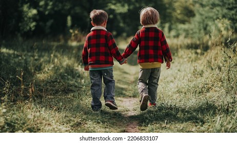 Cute Kids Walking Together Holding Hands In Autumn Park. Smiling Brothers, Stylish Boys Having Fun, Playing Outdoors. Friendship, Family, Twins, Childhood Concept. High Quality Photo