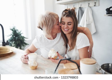 Cute kiss. Mother and daughter having good time in the kitchen. - Shutterstock ID 1323798803
