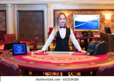 Cute lady casino dealer at Black Jack table.