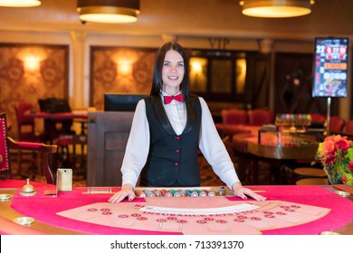 Cute Lady Casino Dealer At Poker Table.