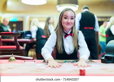 Cute Lady Casino Dealer At Poker Table.