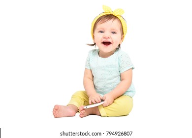 Cute Laughing Baby Girl, Sitting With A Mobile Phone, Isolated On White Background