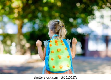 Cute little adorable toddler girl on her first day going to playschool. Healthy beautiful baby walking to nursery preschool and kindergarten. Happy child with backpack on the city street, outdoors.