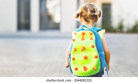 Cute little adorable toddler girl on her first day going to playschool. Healthy beautiful baby walking to nursery school and kindergarten. Happy child with backpack, unrecognizable face.