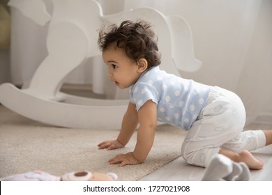 Cute Little African American Baby Infant Go On Hands And Knees On Cozy Warm Wooden Floor With Carpet, Small Biracial Toddler Child Girl Boy Learn Walking Creeping On Fours At Home, Childcare Concept