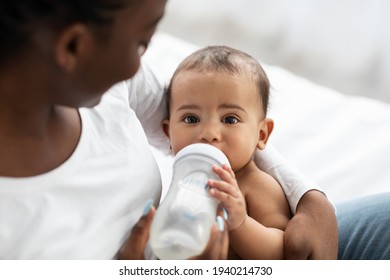 Cute little African American baby drinking from baby bottle - Powered by Shutterstock