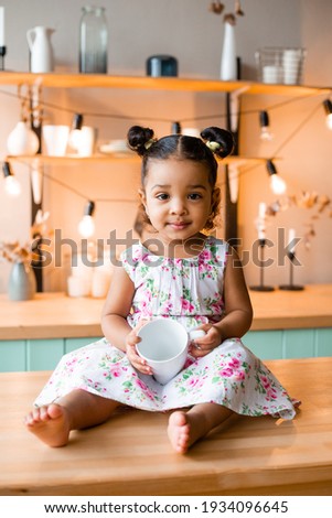 Similar – Image, Stock Photo A baby girl is spoon fed with yogurt by her mother