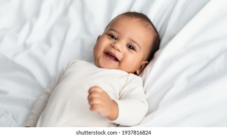 Cute little African American infant lying in bed