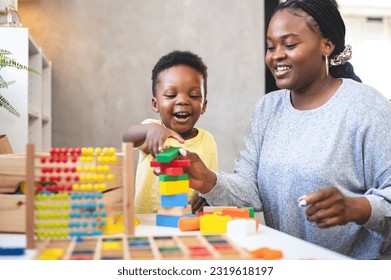 A cute little African child plays with colorful didactic educational toys. His proud mother supports him. Kindergarten teacher with child. - Powered by Shutterstock