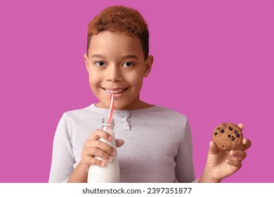 Cute little African-American boy eating cookie with milk on purple background - Powered by Shutterstock