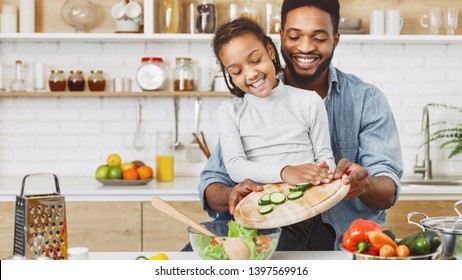 Cute Little Afro Girl And His Father Making Salad Together. Happy Childhood Concept, Copy Space