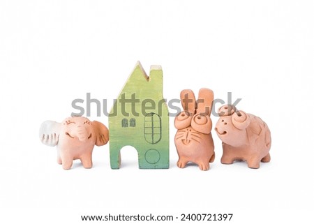 Cute little animal clay doll with wooden miniature house isolate on white background, garden decoration item, animal home