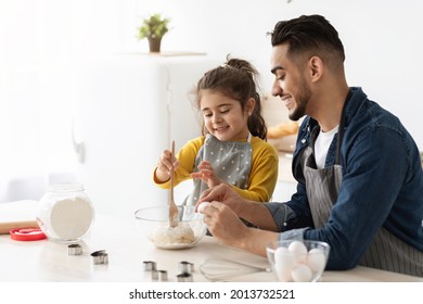 Cute Little Arab Girl Baking With Father In Kitchen, Preparing Dough For Cookies, Adorable Female Child And Her Middle Eastern Dad Enjoying Cooking Pastry Together At Home, Closeup With Copy Space