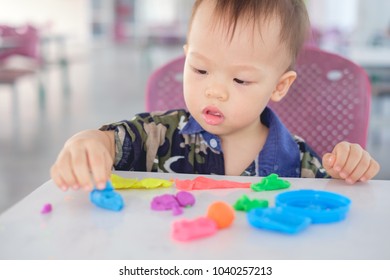 Cute Little Asian 18 Months Old Toddler Baby Boy Child Having Fun Playing Colorful Modeling Clay / Play Dought At Play School / Child Care, Educational Toys For Kid Creative Play For Toddlers Concept