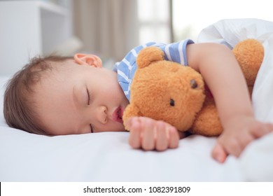 Cute Little Asian 18 Months / 1 Year Old Toddler Boy Child Sleeping / Taking A Nap Under Blanket In Bed While Hugging Teddy Bear, Daytime Sleep, Kid Deep Sleeping, Sweet Dream Concept With Copy Space