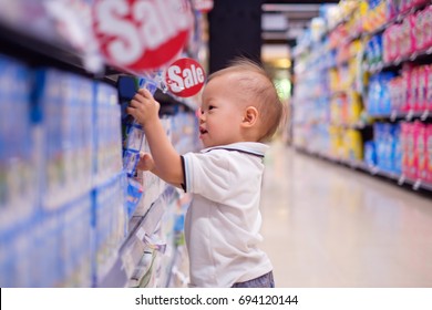 Cute Little Asian 18 Months / 1 Year Old Toddler Baby Boy Child Standing And Choosing Milk Product In Grocery Store / Department Store, Kid Purchasing Milk In Shop