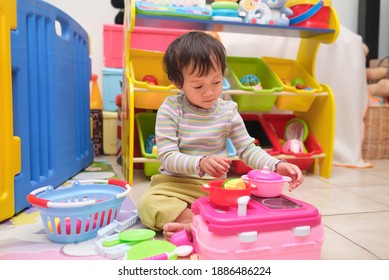 Cute Little Asian 2 - 3 Years Old Toddler Girl Child Having Fun Playing Alone With Cooking Toys, Kitchen Set At Home, Pretend And Role Play Toys For Young Kid, Educational Toys For Children Concept