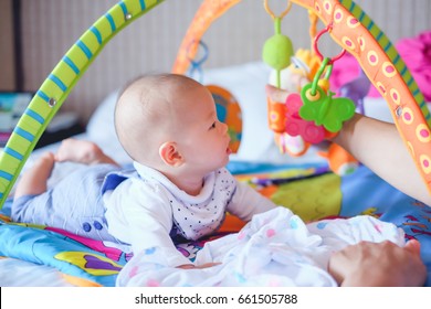 Cute Little Asian 5 - 6 Months Old  Baby Boy Child At Tummy Time On The Play Gym Playing With His Daddy On Bed In Bedroom At Home - Selective Focus