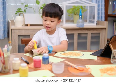 Cute little Asian 5 years old toddler boy enjoy using glue doing arts at home, Fun paper and glue crafts for toddlers, Children's Art Project, DIY Toys for kids from Recyclable Materials concept - Powered by Shutterstock