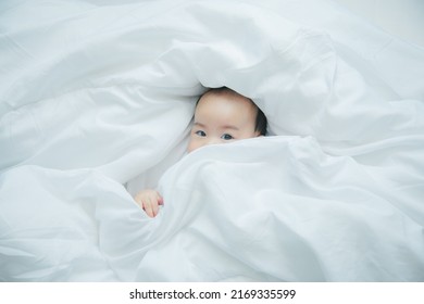 Cute little asian baby lying on bed with soft blanket indoors - Shutterstock ID 2169335599
