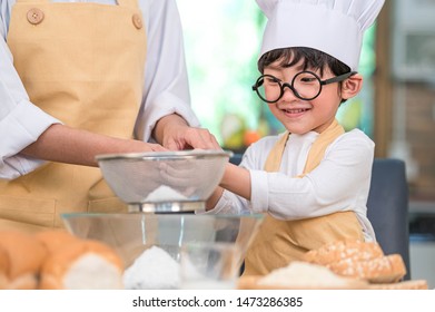 Cute little Asian boy and beautiful mother sifting dough flour with sifter sieve colander in home kitchen on table for prepare to baking bakery and cake. Thai kids playing with flour as chef funny - Powered by Shutterstock