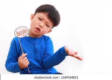 Cute little asian boy holding booth prop with "bojio" note, literally translates as "never invite" with funny expression, isolated on white background. - Powered by Shutterstock