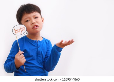 Cute little asian boy holding booth prop with "bojio" note, literally translates as "never invite" with funny expression, isolated on white background. - Powered by Shutterstock