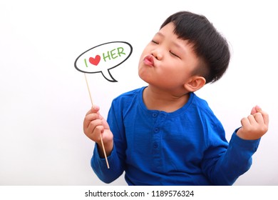 Cute little asian boy holding booth prop with "i love her" note, with funny expression, isolated on white background. - Powered by Shutterstock