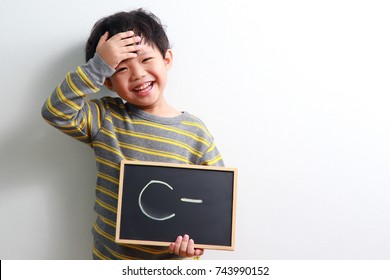 Cute Little Asian Boy Holding A Chalk Board With The C- Sign.