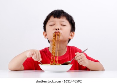 Cute Little Asian Boy With Red T-shirt Enjoying Eating Wonton Noodles At Home. Tasty Food.