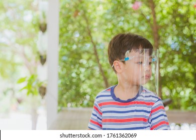 Cute Little Asian Boy Wear Face Mask And Sheild As Protection During The Covid 19 Virus Outbreak. Copy Space.