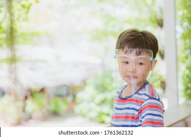 Cute Little Asian Boy Wear Face Mask And Sheild As Protection During The Covid 19 Virus Outbreak. Copy Space.