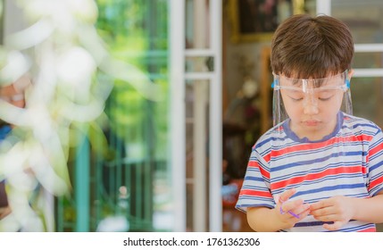 Cute Little Asian Boy Wear Face Mask And Sheild As Protection During The Covid 19 Virus Outbreak. Copy Space.