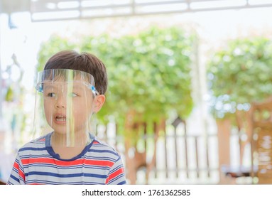 Cute Little Asian Boy Wear Face Mask And Sheild As Protection During The Covid 19 Virus Outbreak. Copy Space.