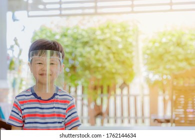 Cute Little Asian Boy Wear Face Mask And Sheild As Protection During The Covid 19 Virus Outbreak. Copy Space.