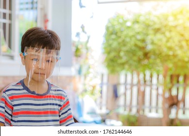 Cute Little Asian Boy Wear Face Mask And Sheild As Protection During The Covid 19 Virus Outbreak. Copy Space.